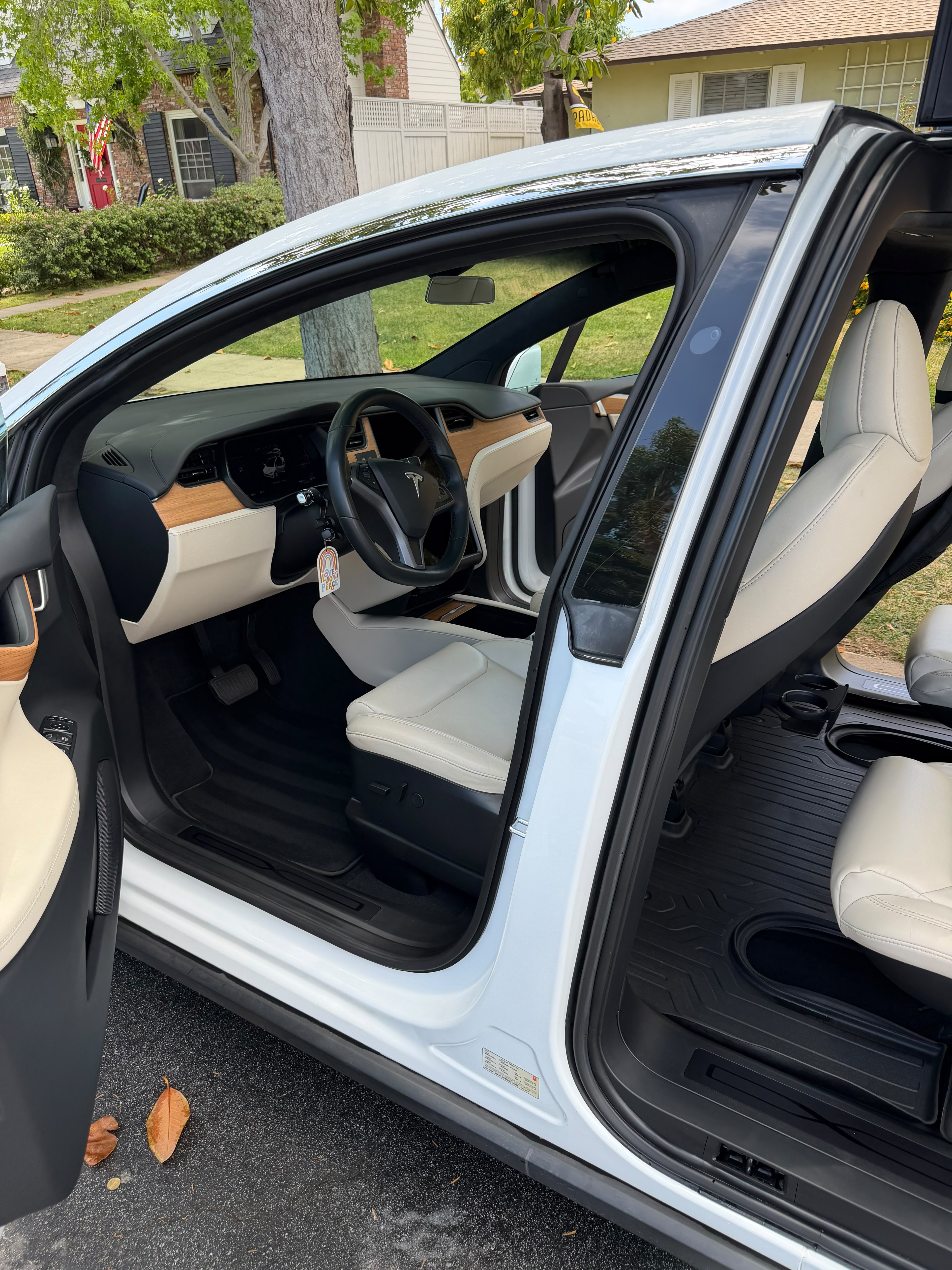 Interior car detailing in Riverside & San Diego County, electric SUV cabin with cleaned white leather seats, dashboard, and door sill