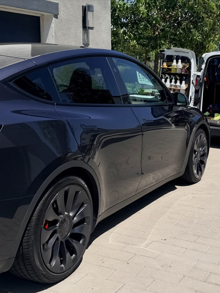 Mobile detailing service at a customer's home in Riverside & San Diego County, electric SUV detailed in the driveway beside the stocked Royal Rinse van